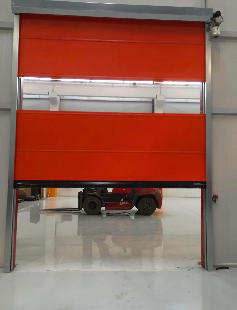 Üretim tesisinde forklift geçişine açılmış kırmızı fermuarlı hızlı PVC kapı